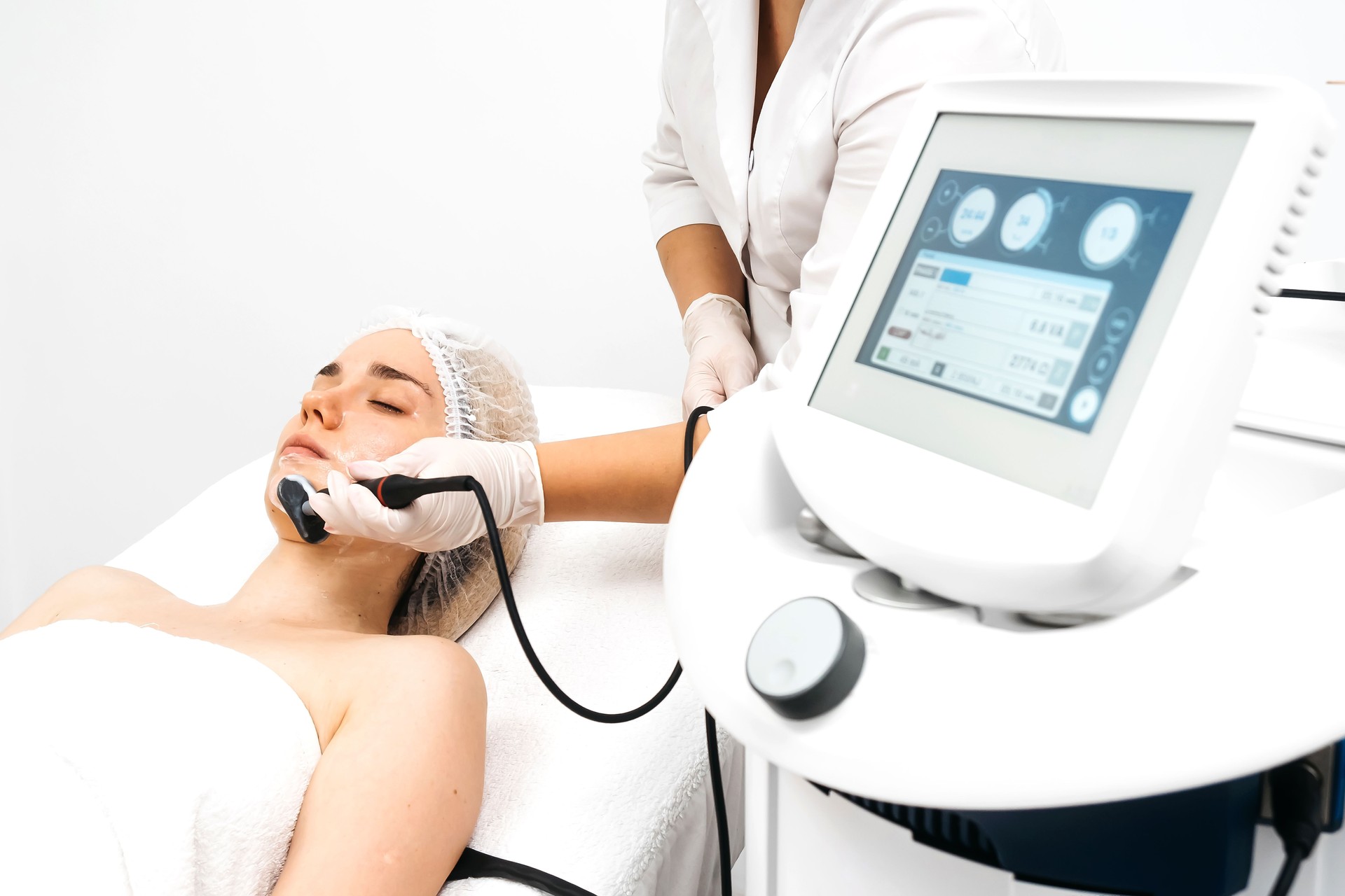 A cosmetologist applies radiofrequency lifting to a young woman in a modern clinic. This advanced procedure tightens skin and promotes rejuvenation, ideal for showcasing beauty treatments.